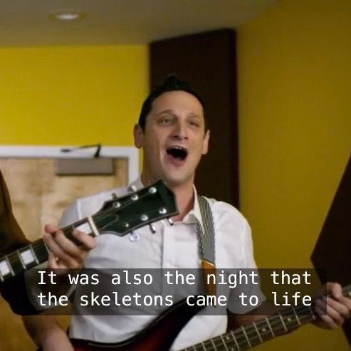 Tim Robinson playing bass and singing “it was also the night that the skeletons came to life”