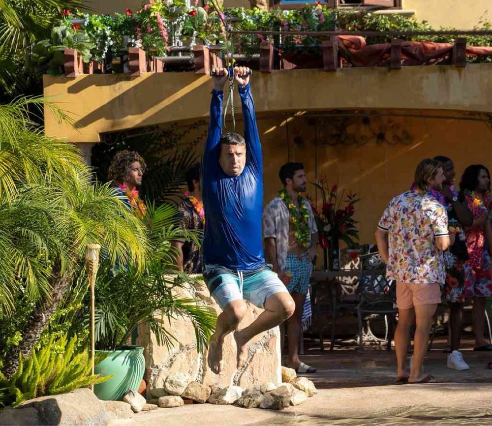 Tim Robinson riding a zipline into the pool