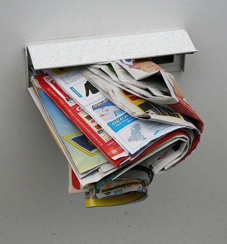 Buzón normal lleno de publicidad en papel de múltiples tiendas