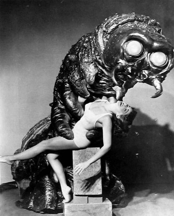 Promo shot from The Monster That Challenged the World showing a large mollusk monster being a good partner and supporting a lady in a swimsuit happily leaning back 