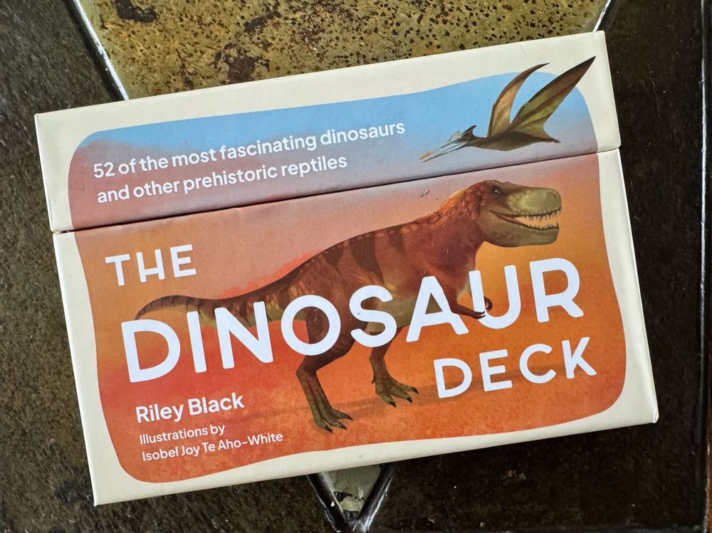 The box for The Dinosaur Deck showing a Tyrannosaurus and a pterosaur, cards written by Riley Black 