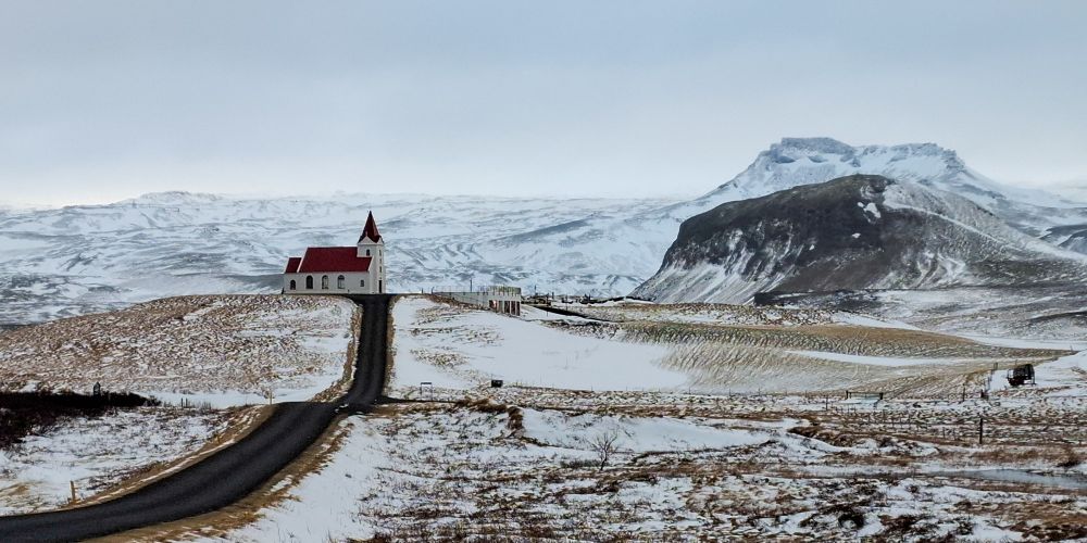 Church wifh backdrop of snowwy mountains. Hellissandur, Iceland.