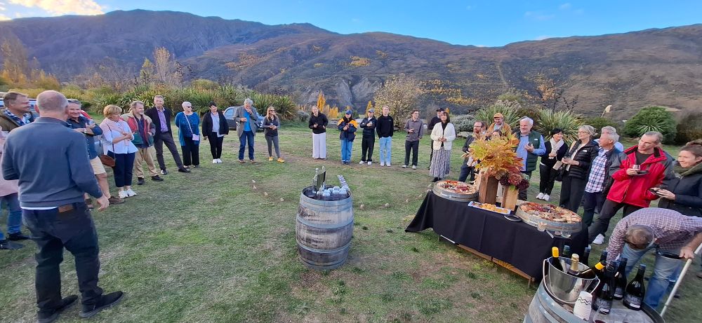 Brian Boyle delivers opening speech to about 50 people in a garden in a vineyard.