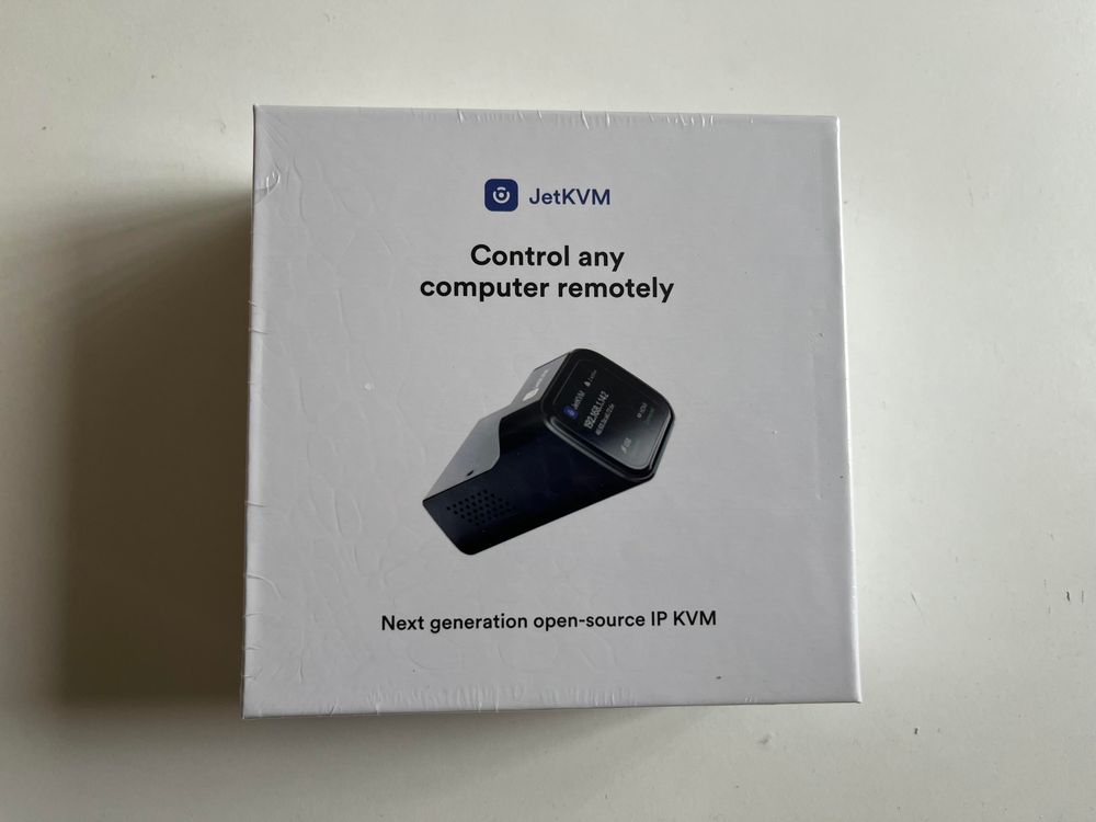 The box of a JetKVM. It’s square and white, with a picture of the device in the middle.

It’s surprisingly nice packaging.