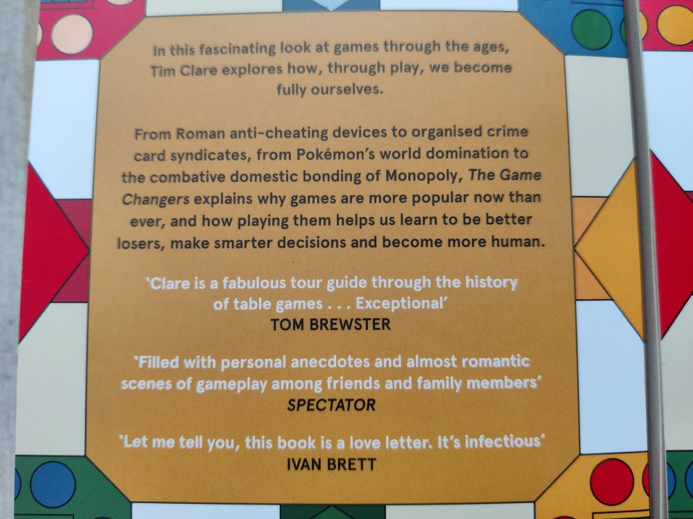 The back cover, with pull quotes and a blurb which reads:

'Why is playing games a universal human instinct?
And how can those games make your life happier, healthier and more fulfilled?

In this fascinating look at games through the ages, Tim Clare explores how, through play, we become fully ourselves.

From Roman anti-cheating devices to organised crime card syndicates, from Pokémon's world domination to the combative domestic bonding ritual of Monopoly, The Game Changers explains why games are more popular now than ever, and how playing them helps us learn to be better losers, make smarter decisions and become more human'
