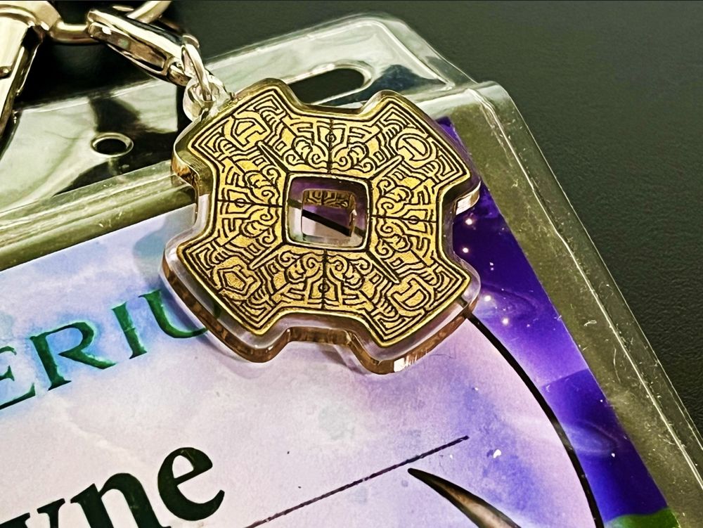 A lanyard charm depicting the Bahro tablet from Myst V
