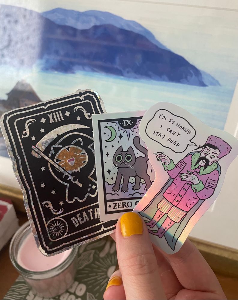 Three holographic stickers; a death kitty, a zero chill kitty, and lil horny Orlok
