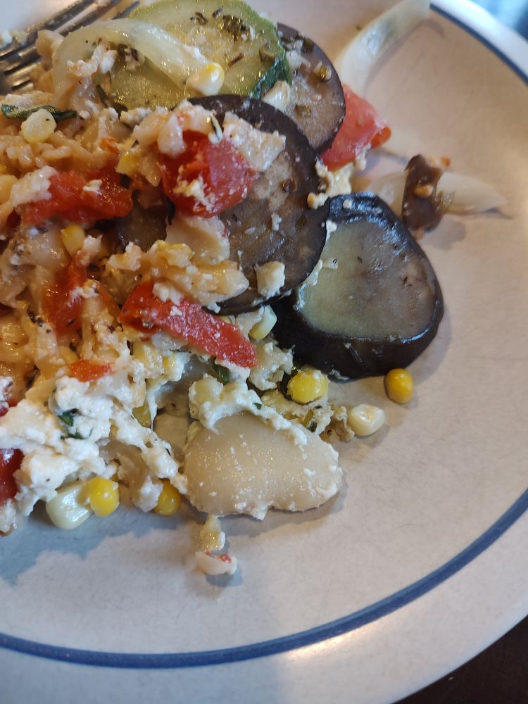A serving of the previously pictured dish scooped onto a plate. Now the veggies are mixed and you can see ricotta, large white beans, and pasta mixed in. 