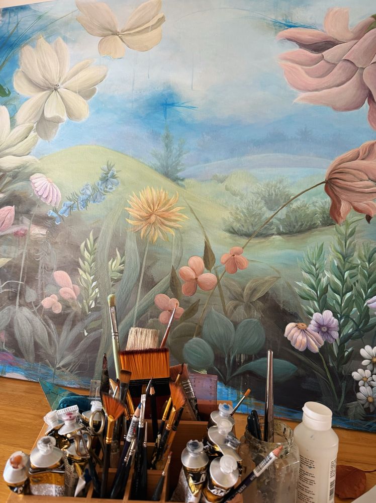 Detail of a floral acrylic painting with brushes and tools. 