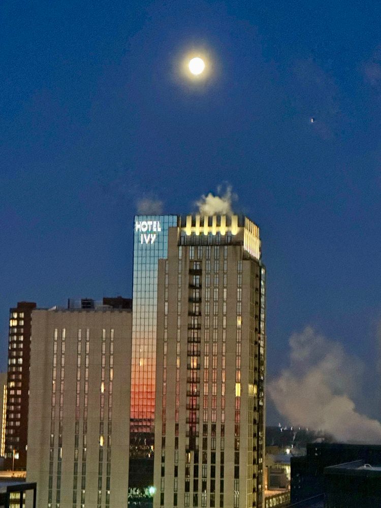 Full moon over Mpls with the sunrise reflecting on the Hotel Ivy.