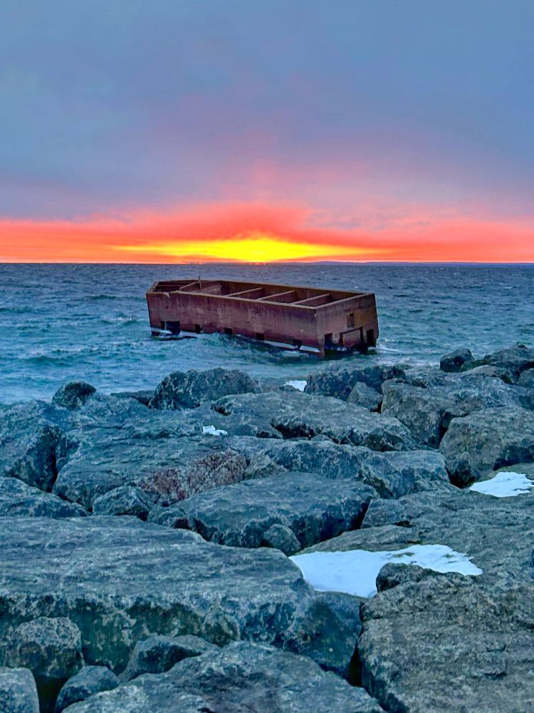 Red and yellow sunrise over Uncle Harvey’s Mausoleum also known as the Cribs (old loading dock) on Lake Superior
