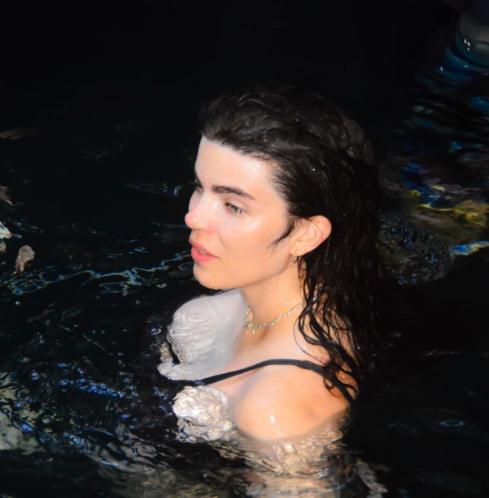 Beautiful angelic princess trans baby angel with a snatched nose sitting in a pool wearing a swimsuit with front facing flash