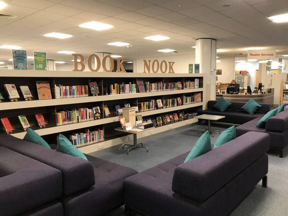 A photograph of the Book Nook. A new reading for pleasure collection on level two of the library. Photo shows some bookshelves and sofas. 