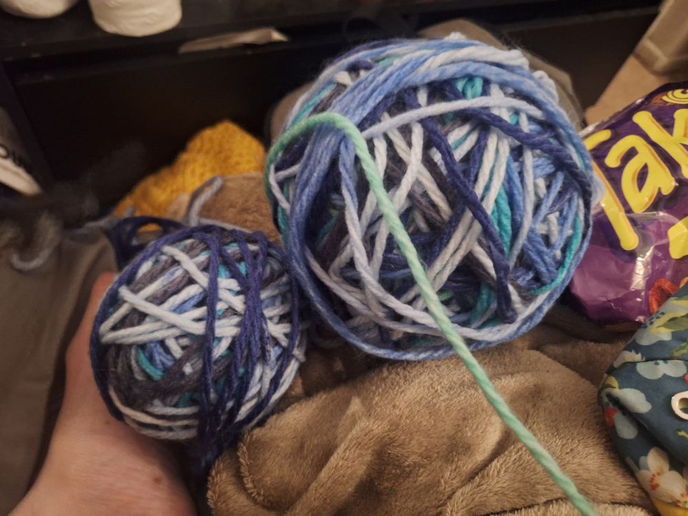 Two blue multicolored yarn balls