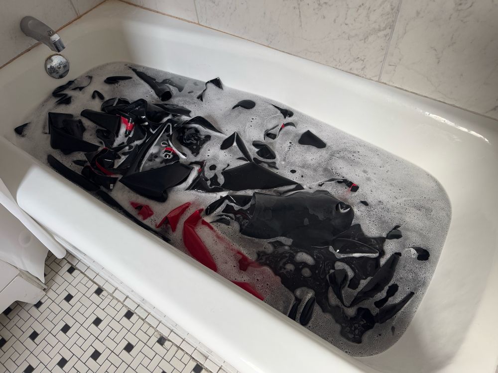 Rubber gear in a bathtub with soap bubbles.