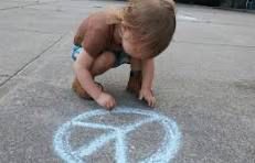 Image of a young child drawing a blue peace symbol on a sidewalk.