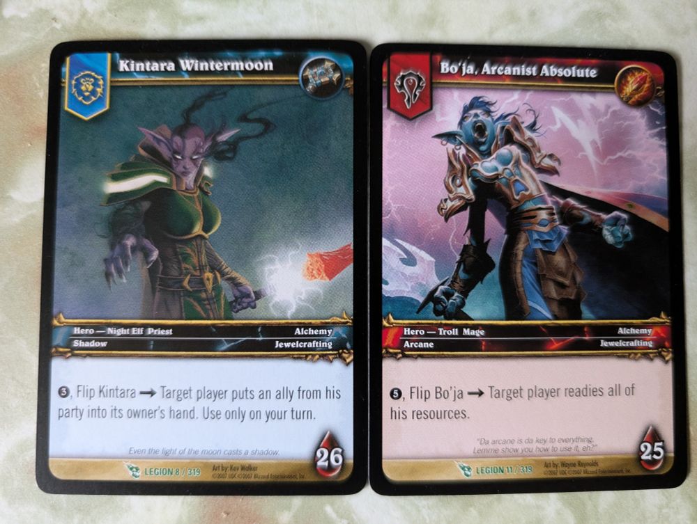 Two World Of Warcraft hero cards. One Alliance, one Horde. In both of the heroes' ability descriptions it refers to the player as "his". 
