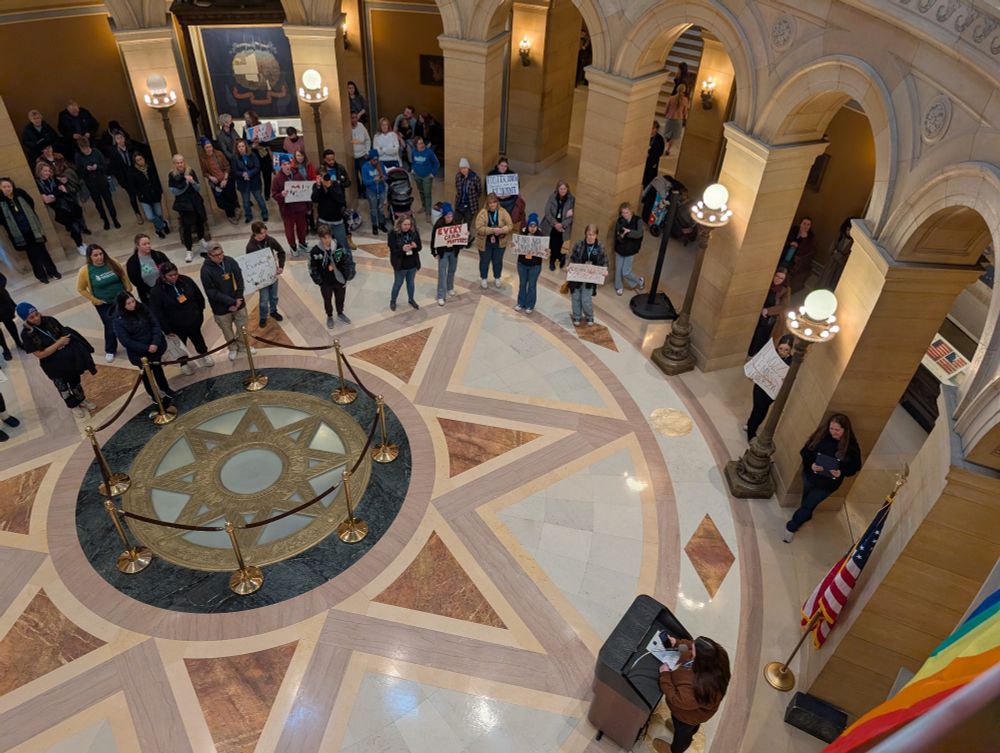 MN capitol rotunda with various pride flags and people