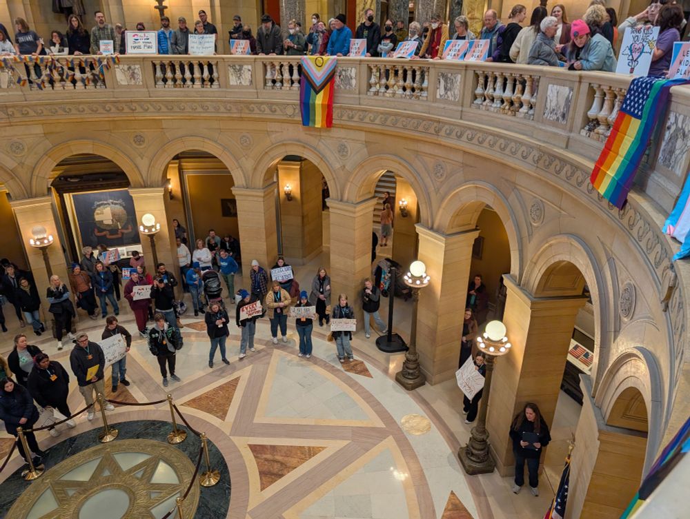 MN capitol rotunda with various pride flags and people