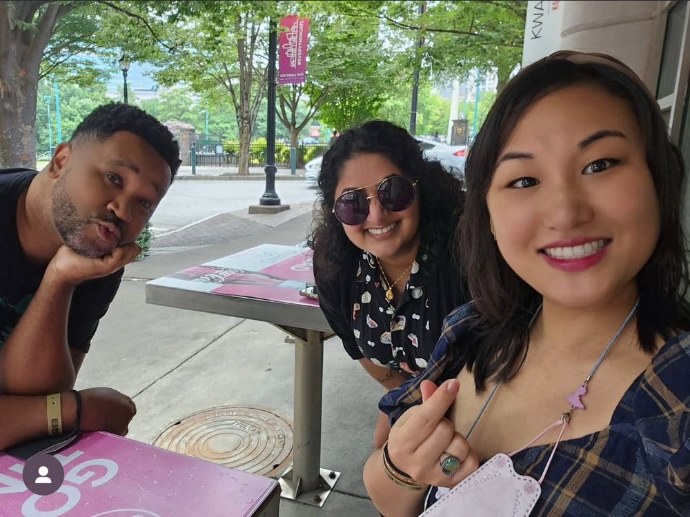 A picture of me, Kat, and Julian Winters smiling and sitting outside together