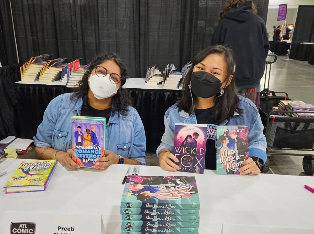 Kat and I masked and sitting at our signing table together. We’re both obviously smiling under our masks. I’m holding a copy of PAYAL MEHTA’S ROMANCE REVENGE PLOT and Kat has copies of her books, WICKED FOX and ONCE UPON A K-PROM 