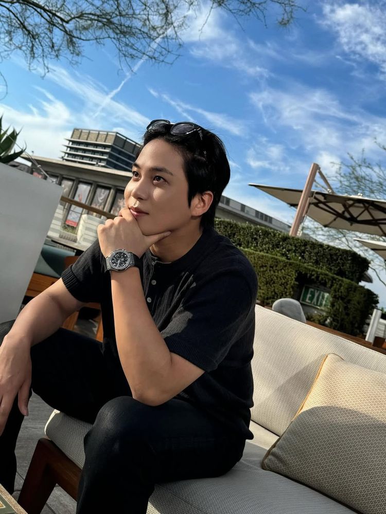 kpop group ateez member choi jongho photographed seated in an outdoor restaurant area