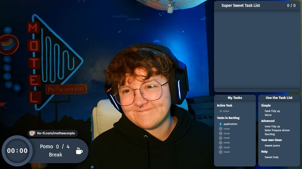 a screenshot from mo's OBS software. it depicts mo smiling softly looking to the side of the camera. they have a black hoodie, black headphones, black round glasses, and a silver septum ring on. the background is a custom painted mural by their partner jordan that shows a neon blue adn red motel sign that also says "Mo The Scorpio" with a rainbow flag also incorporated into the sky. there are 4 pomos in today's coworking session, mo's kofi link, an emtpy task list, and the instructions on how to use Super Sweet Bot. !sweet !task !done
