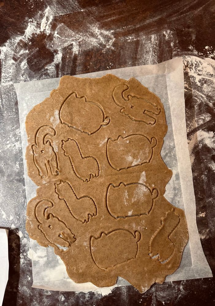 Gingerbread cookie dough, cut with cat and alpaca cookie cutters 