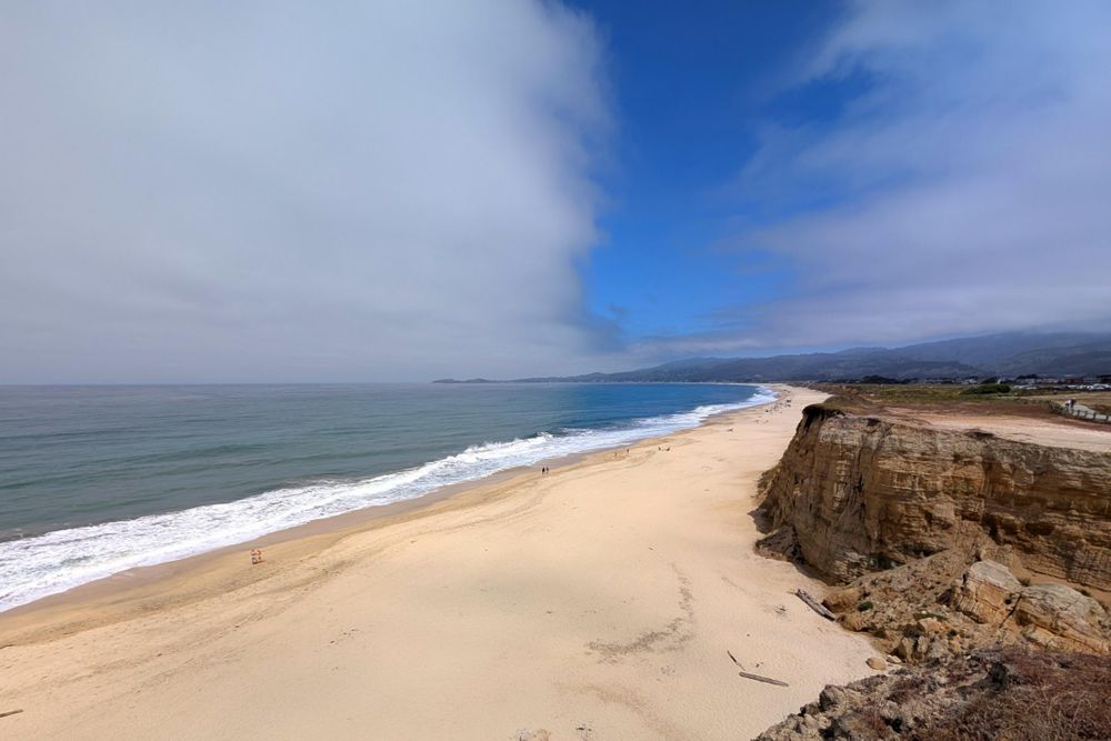Those clouds! It looks like two separate cloud banks with small blue separation between them. Oh, and below the cliffs are cliffs, a white sand beach, and the ocean.