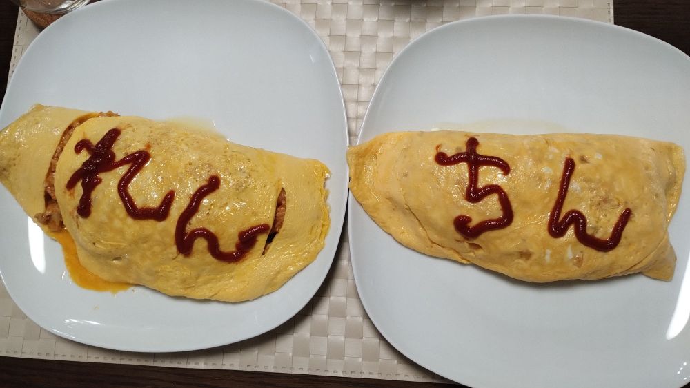 ケチャップで"れん"と"ちん"と書かれた2つのオムライス
