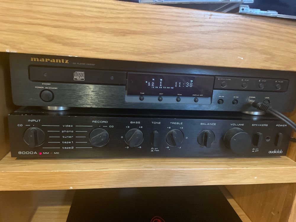 Photo shows a marantz CD player and Rotel hi fi amplifier on a wooden media cabinet