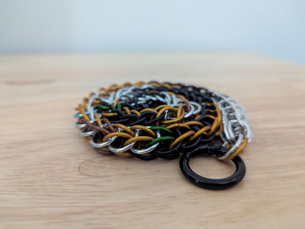 Lucky Paws custom chain collar in a "calico" design using shiny silver, matte black, matte orange, matte brown, and matte green rings.