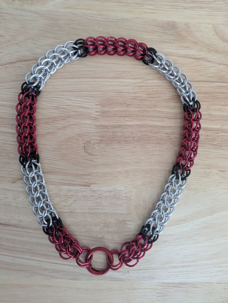Chainmail collar using the shiny black, red, and silver in the design of the Umbrella Corp logo from Resident Evil