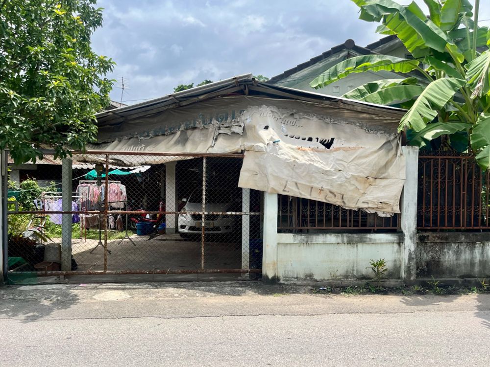 A house on the street with a tattered awning 