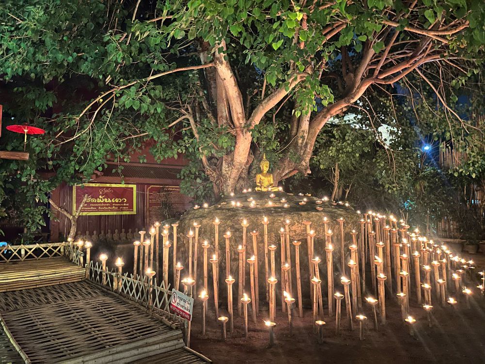 Candles in front of a statue of the Buddha 