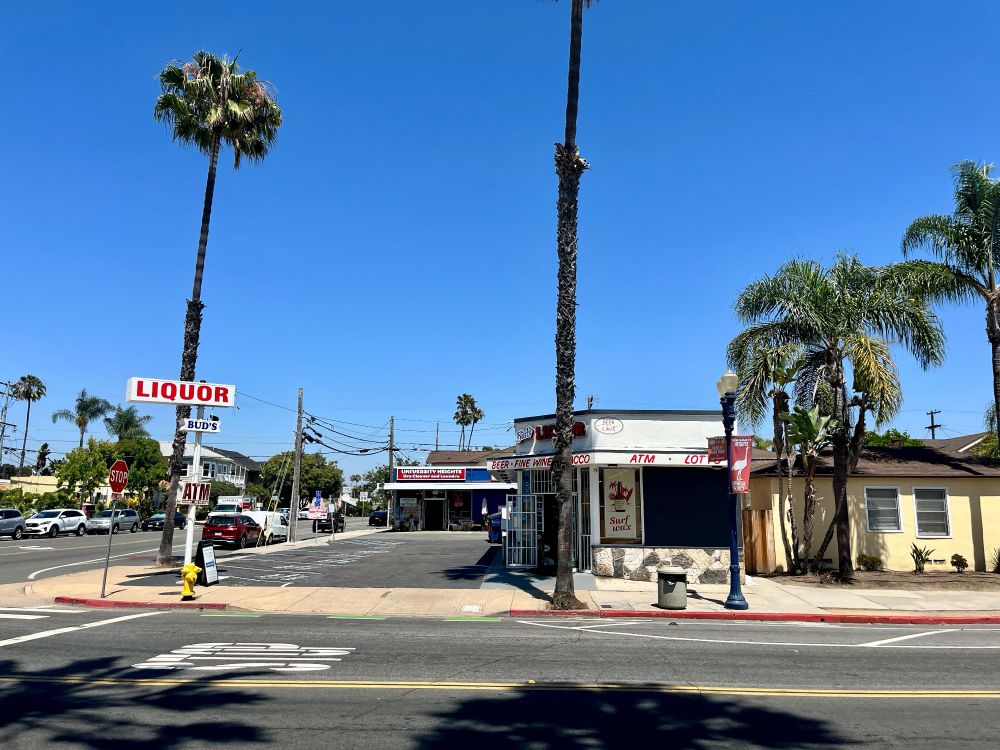 A corner liquor store with palm trees 