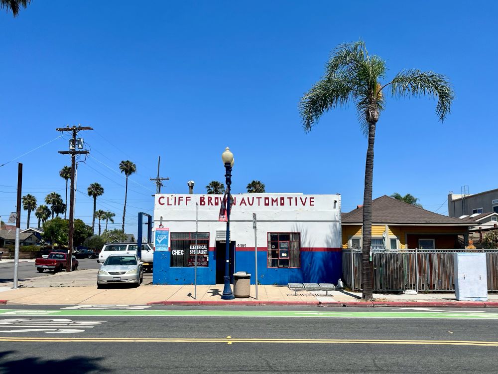 A blue and white auto repair shop on a sunny afternoon 