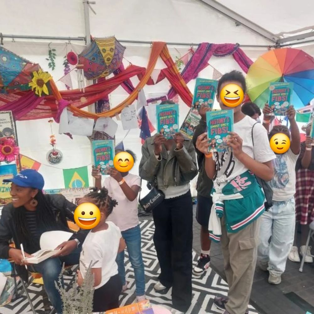 Children hold up copies of Histories most epic ribs. The author Athena Kugblenu is signing a copy 