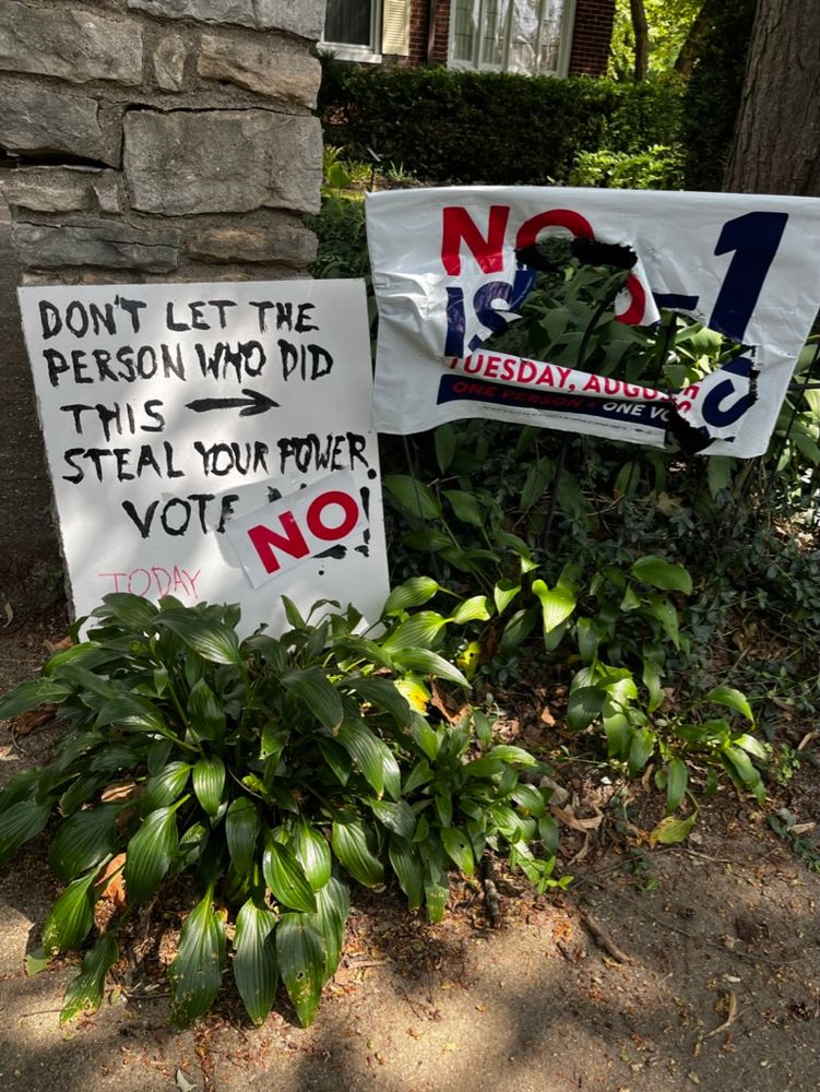 Two signs in a front yard. The one on the right has been slashed to pieces. It is a sign urging voters to vote no on Issue 1 - convoluted language out out by OH's Secy of State meant that you had to vote no in order for abortion to be put on the November ballot referenda. The one on the left has an arrow pointing to the sign on the right and reads, "Don;t let the person who did this [arrow] steal your power. Vote NO! today."