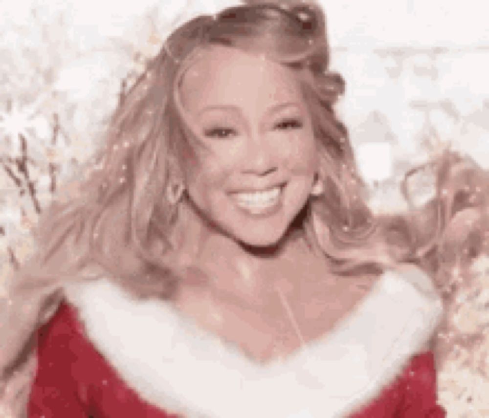 mariah carey is wearing a santa suit and smiling .