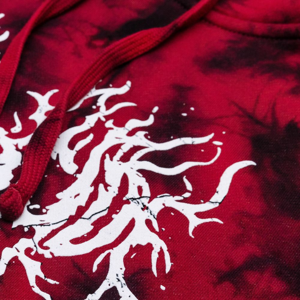 detail shot of a black and red tie-dyed garment. two drawstrings partially overlap a design screenprinted in white ink. 