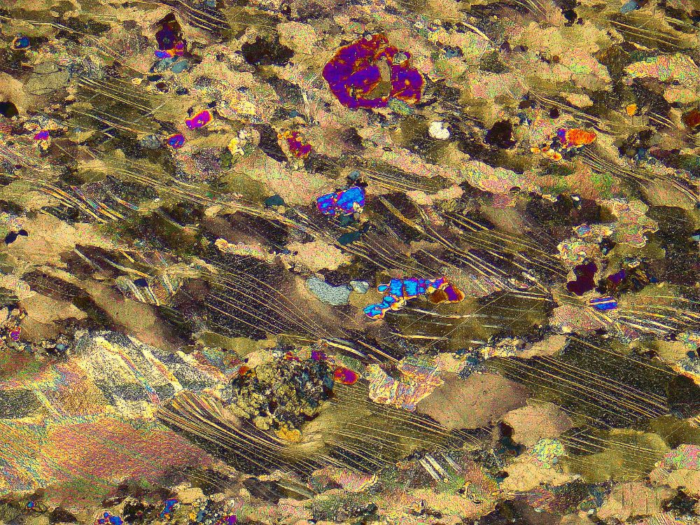 Thin section of deformed contact metamorphosed marble with clinopyroxene blasts surrounded by twinned and deformed calcite. Width: 3 mm. Contact aureole of the Monte Capanne pluton, Elba