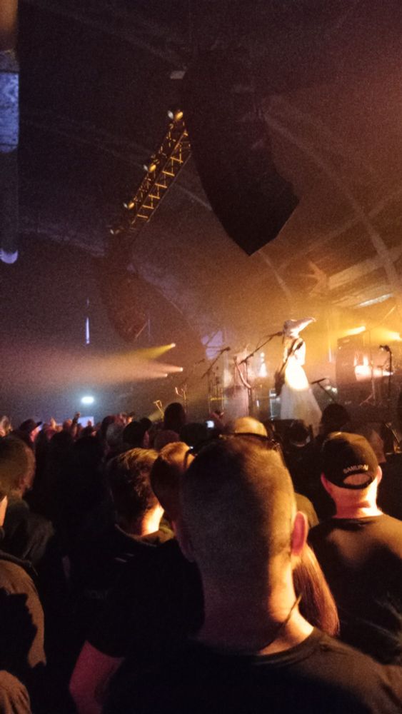 Concert of Witch Club Satan at Roadburn. Picture from the crowd with two bandmembers dressed in white on stage.