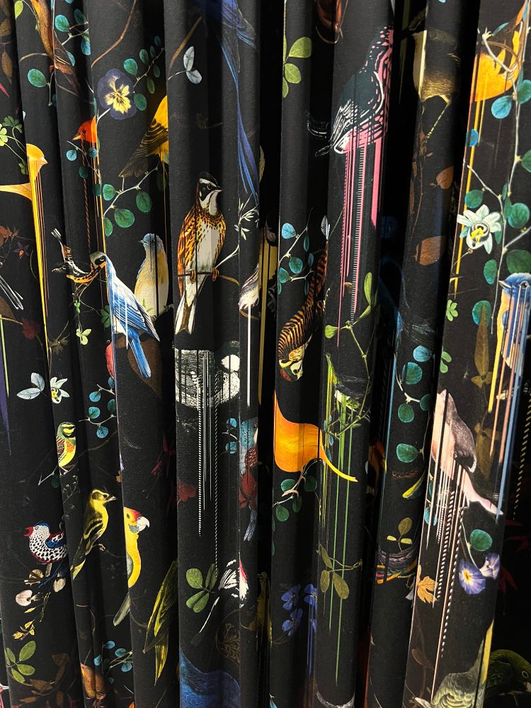 Pictures of various birds on branches with black background. There are vertical stripes running down from the birds. Matches the pattern on the wallpaper in the other image. 