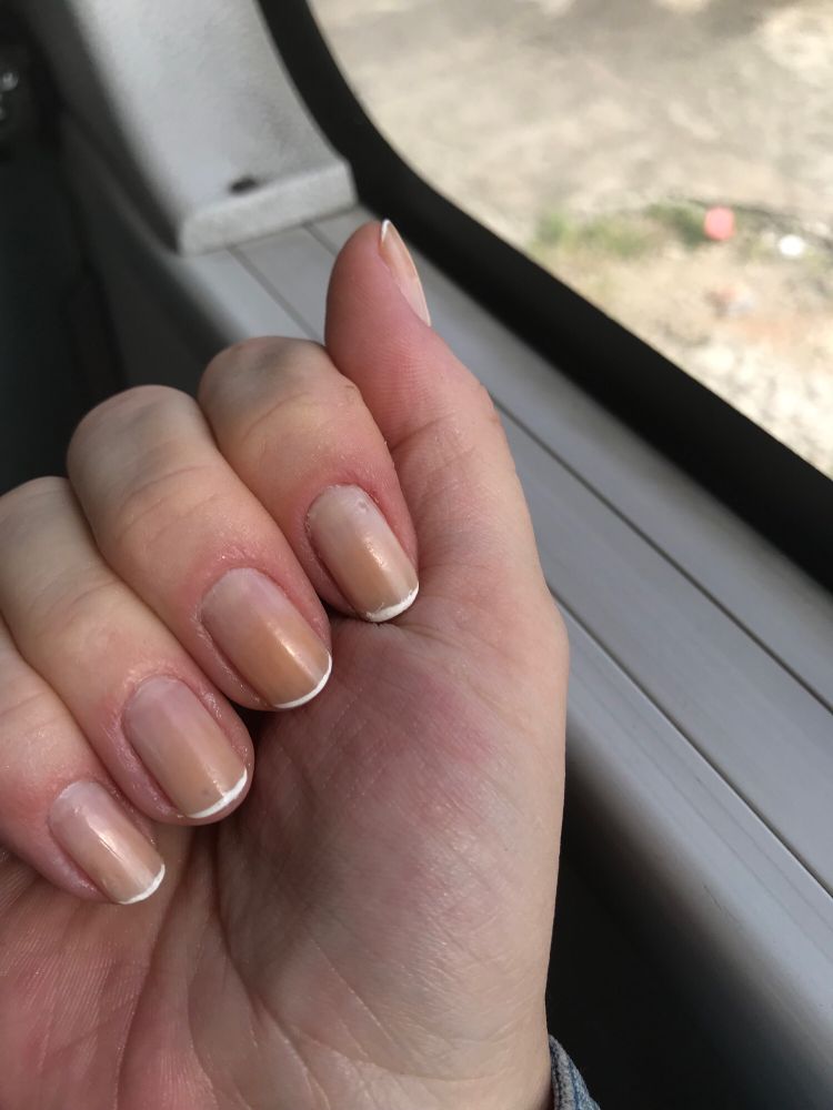 Mão branca fechada mostrando uma francesinha meio borrada