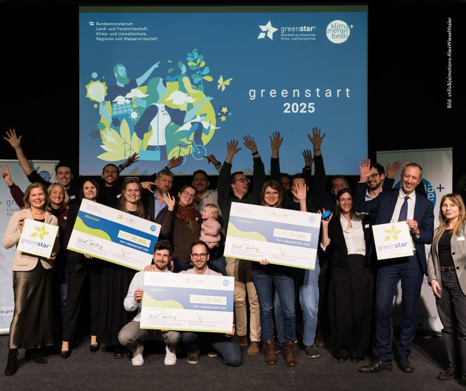 Eine Gruppe von Menschen, die an einem Wettbewerb namens "greenstart 2025" teilnehmen, jubelt und hält Preisscheck-Urkunden hoch.