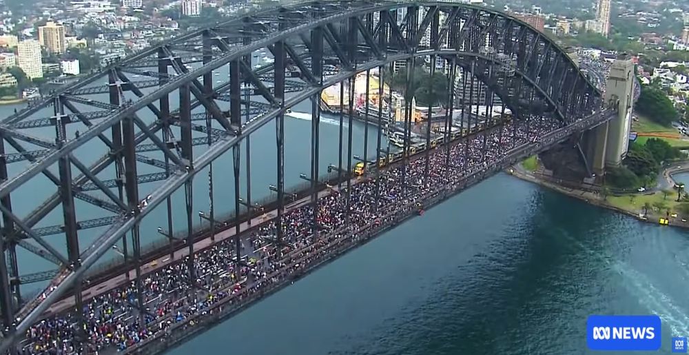 Still from the video in the report that shows the Sydney Harbour Bridge with many thousands of people on it as part of the Gaza protests.