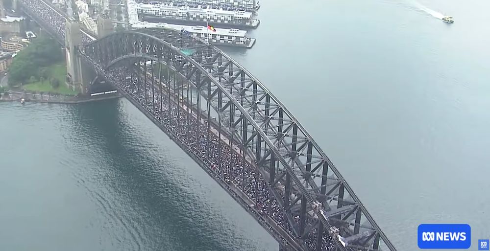 Still from the video in the report that shows the Sydney Harbour Bridge with many thousands of people on it as part of the Gaza protests.