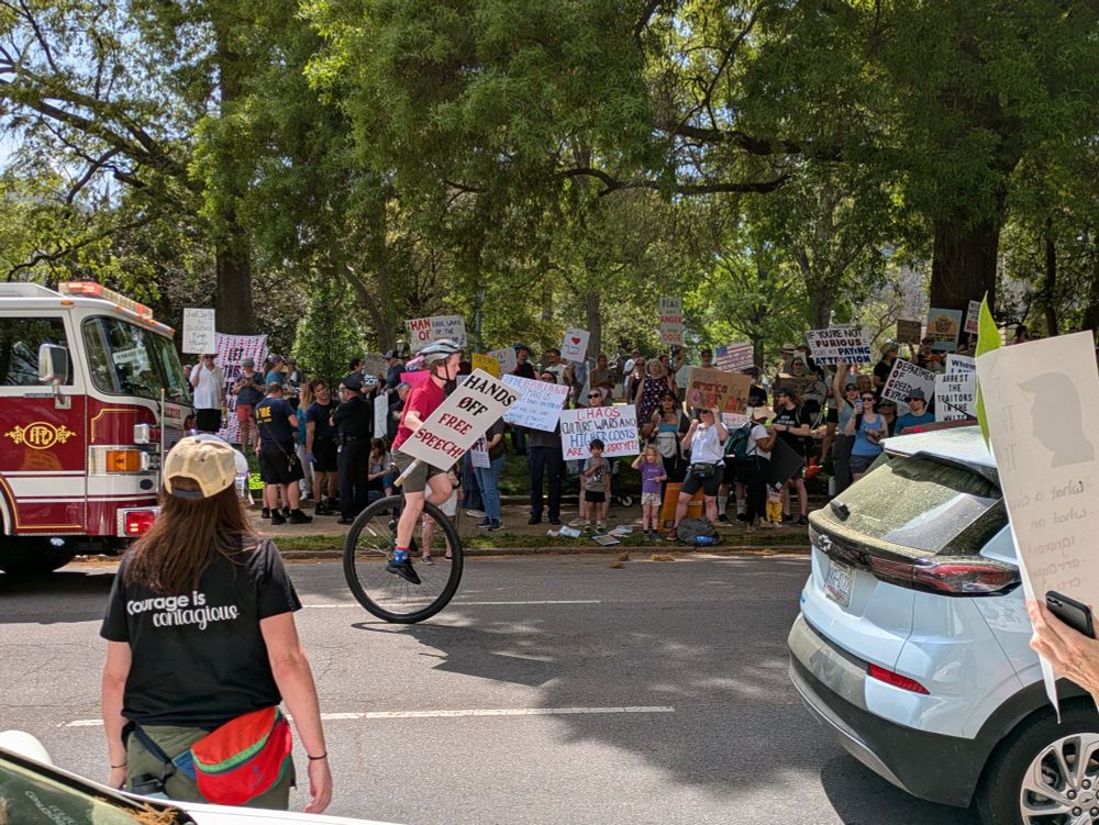 Protestor on a unicycle with Hands Off sign