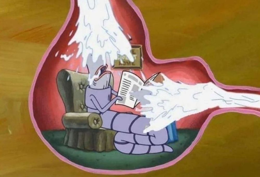 Cartoon of a worm in a stomach reading a paper in an armchair getting sprayed from both ends with white liquid